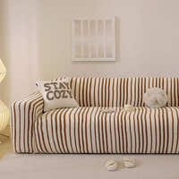 Caramel brown striped stretch sofa cover styled in a warm living room with a cushion