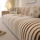Angled close view of the caramel brown striped sofa cover over the seat and armrest