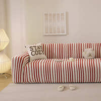 Crimson red striped stretch sofa cover styled in a warm living room with a cushion
