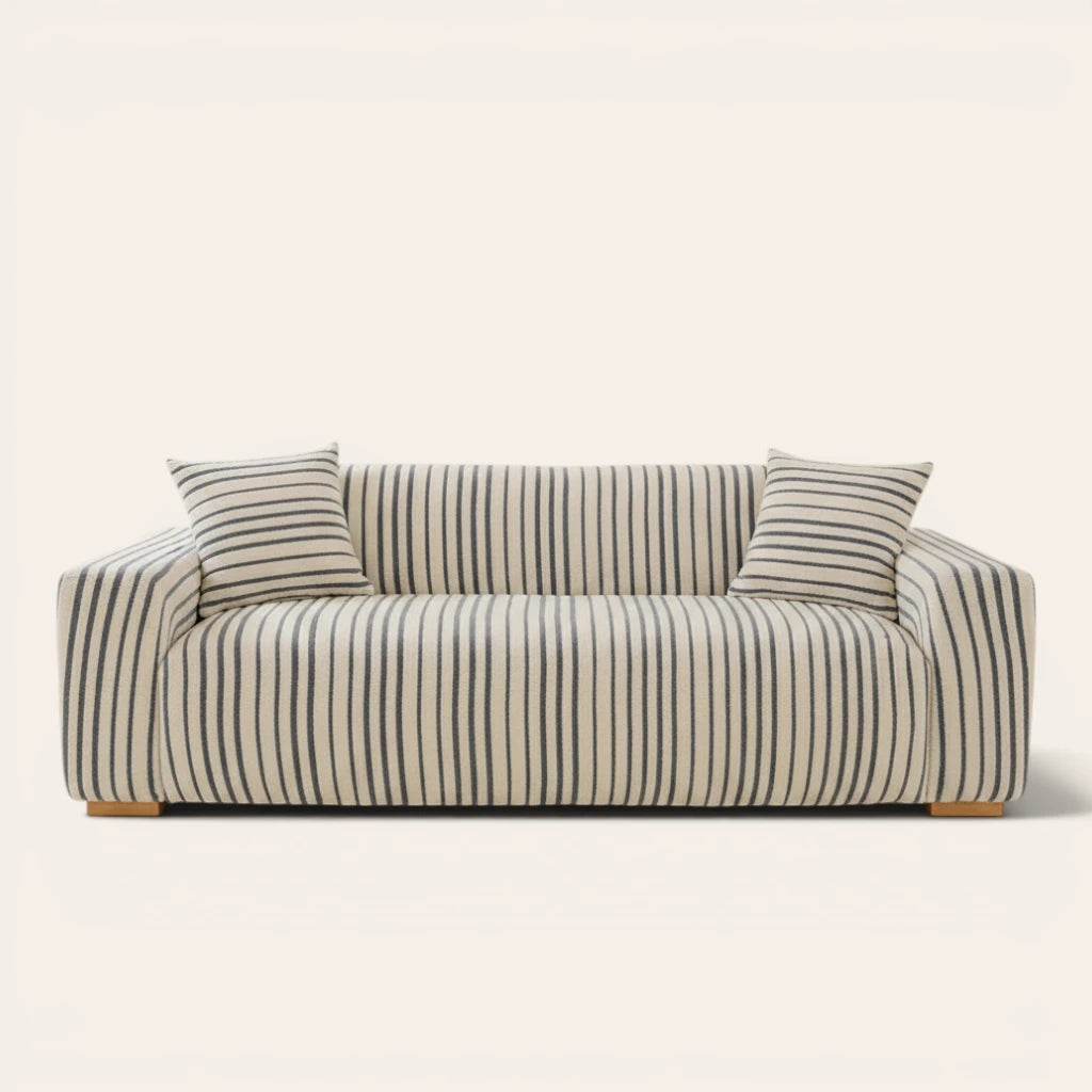 Ocean blue striped sofa cover fitted on a three-seat sofa with matching cushions, front view on ivory