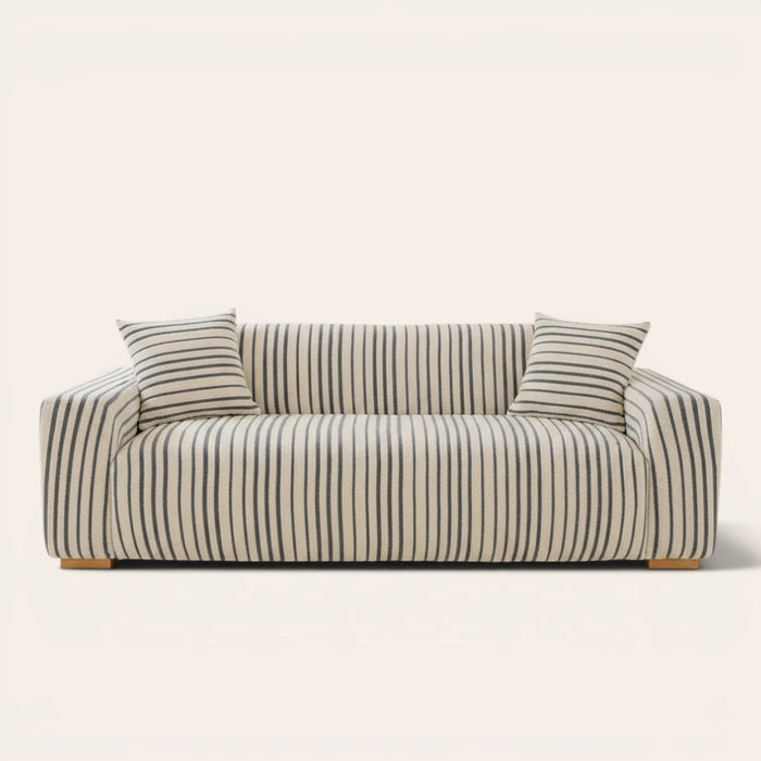 Ocean blue striped sofa cover fitted on a three-seat sofa with matching cushions, front view on ivory