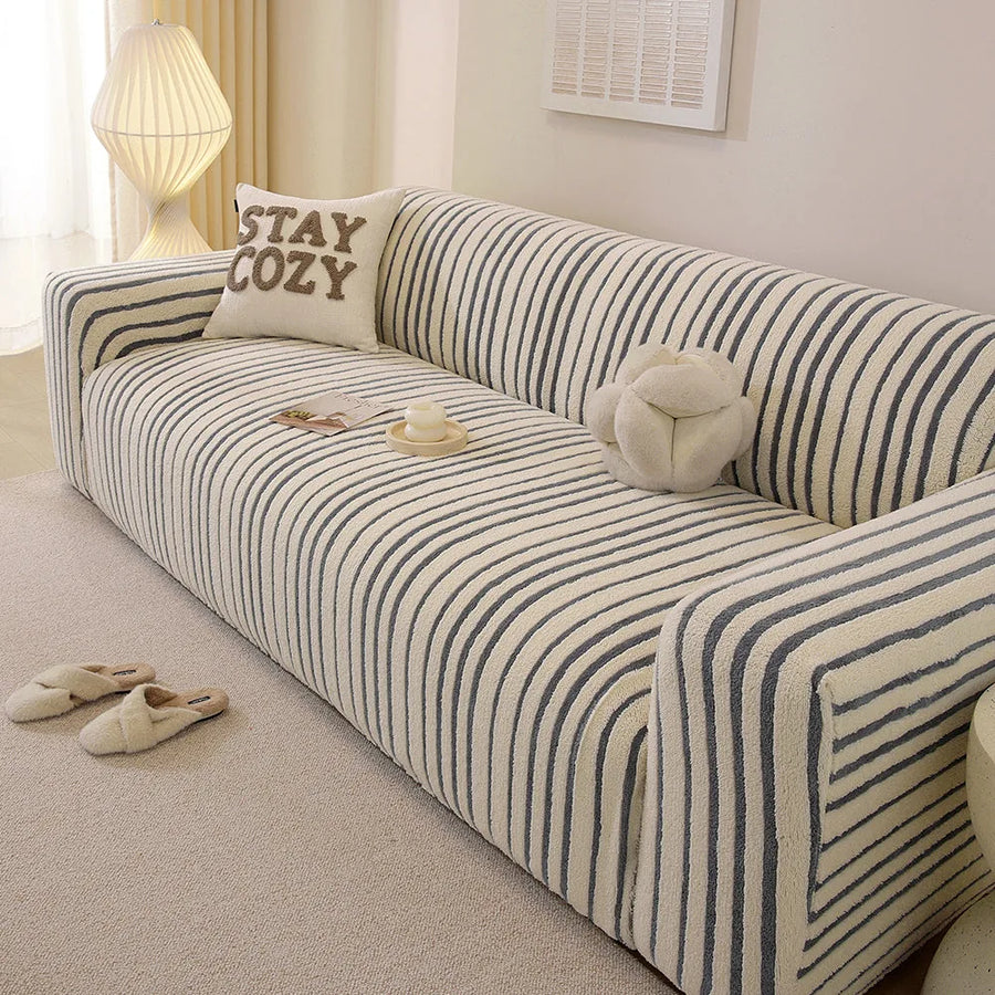 Angled view of the ocean blue striped sofa cover with vertical stripes over the seat and armrest