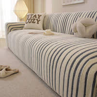 Corner detail of the ocean blue striped sofa cover wrapping the armrest in a bright living room