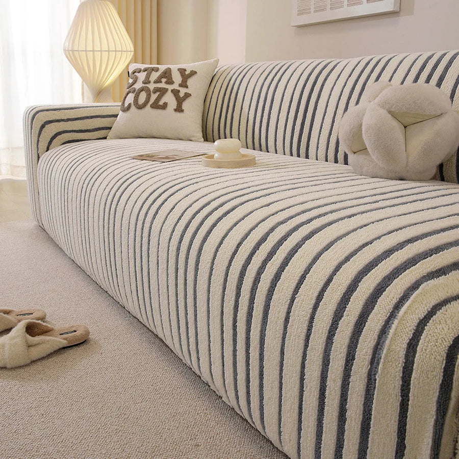 Corner detail of the ocean blue striped sofa cover wrapping the armrest in a bright living room