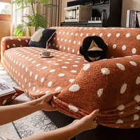 Hands smoothing the caramel teddy polka dot stretch sofa cover over the armrest in a sunlit living room