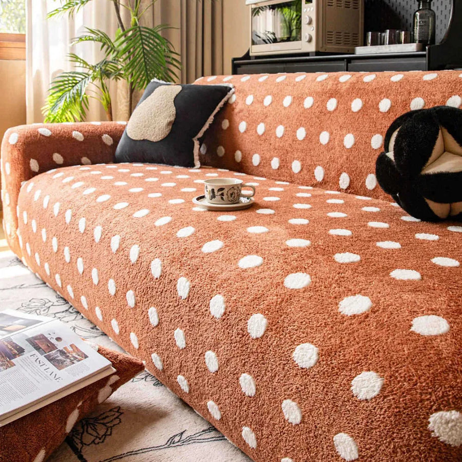Caramel teddy polka dot sofa cover styled with a cushion and coffee cup in a warm living room