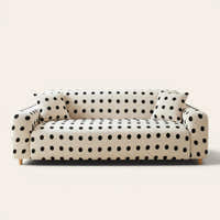 Cream black teddy sofa cover with black polka dots on a three-seat sofa, front view on ivory backdrop