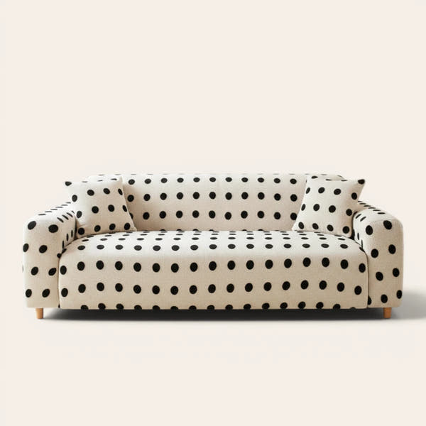 Cream black teddy sofa cover with black polka dots on a three-seat sofa, front view on ivory backdrop