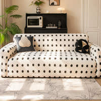 Cream black teddy sofa cover styled in a living room with dark cushions and a palm