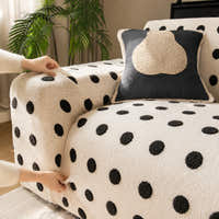 Hands fitting the cream black teddy sofa cover over the armrest to show its stretch