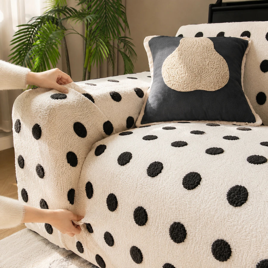Hands fitting the cream black teddy sofa cover over the armrest to show its stretch