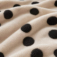 Macro close-up of the cream teddy sherpa with raised tufted black dots