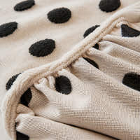 Detail of the elastic gathered hem on the cream black teddy sofa cover underside