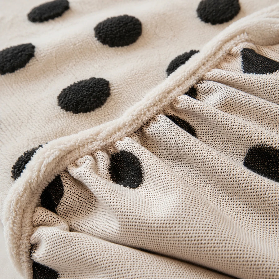 Detail of the elastic gathered hem on the cream black teddy sofa cover underside
