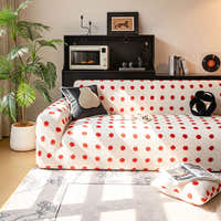 Cream red teddy sofa cover styled in a cozy living room with a dark cushion and a tall plant