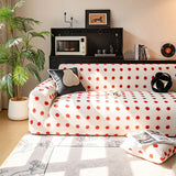 Cream red teddy sofa cover styled in a cozy living room with a dark cushion and a tall plant