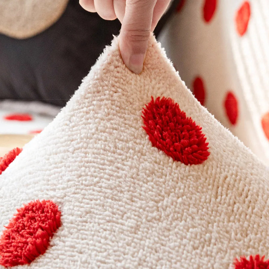 Hand lifting the stretchy cream red teddy sofa cover to show its raised red dots