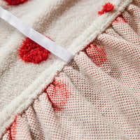 Detail of the elastic gathered hem and piping on the cream red teddy sofa cover