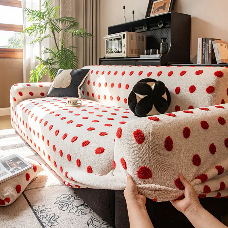 Hands fitting the cream red teddy sofa cover over the armrest to show its stretch