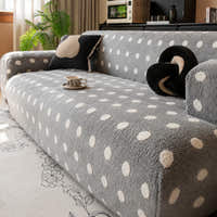 Angled view of the grey snow teddy sofa cover with a coffee cup and accent cushions