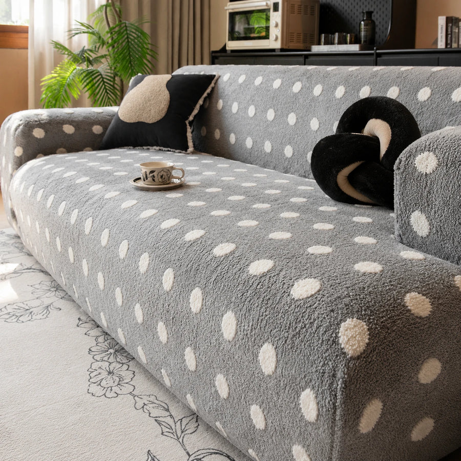 Angled view of the grey snow teddy sofa cover with a coffee cup and accent cushions
