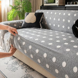 Hands smoothing the grey snow teddy sofa cover over the seat edge for a fitted look