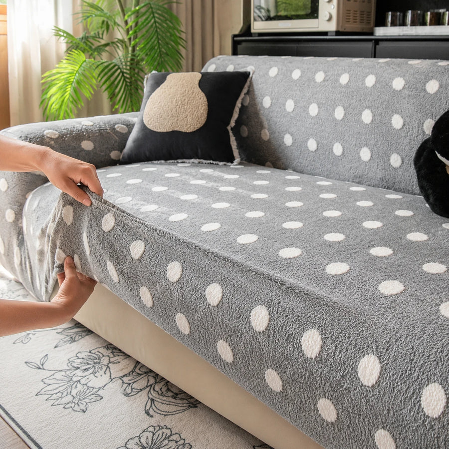 Hands smoothing the grey snow teddy sofa cover over the seat edge for a fitted look