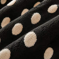 Macro close-up of the black teddy sherpa with raised cream polka dots