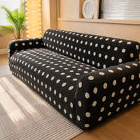 Angled living room view of the midnight dot teddy sofa cover beside a palm and floor lamp
