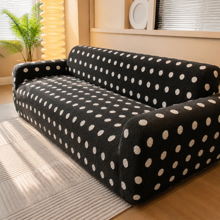 Angled living room view of the midnight dot teddy sofa cover beside a palm and floor lamp