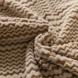 Macro close-up of the almond cream waffle texture with its chevron ribbed knit