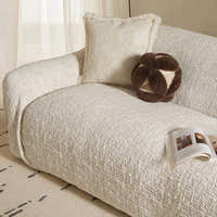 Ivory cream woven sofa cover draped over a chaise section beside sheer curtains and cushions