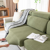 Pulling an olive green corduroy cover into place on the chaise section of a sectional sofa