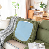 Water sitting in a bead on the surface of an olive green corduroy cushion cover