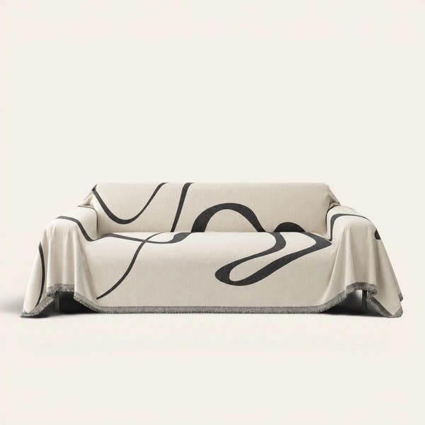 Abstract Haze Abstract Muse sofa throw draped over a full couch, front view on ivory background