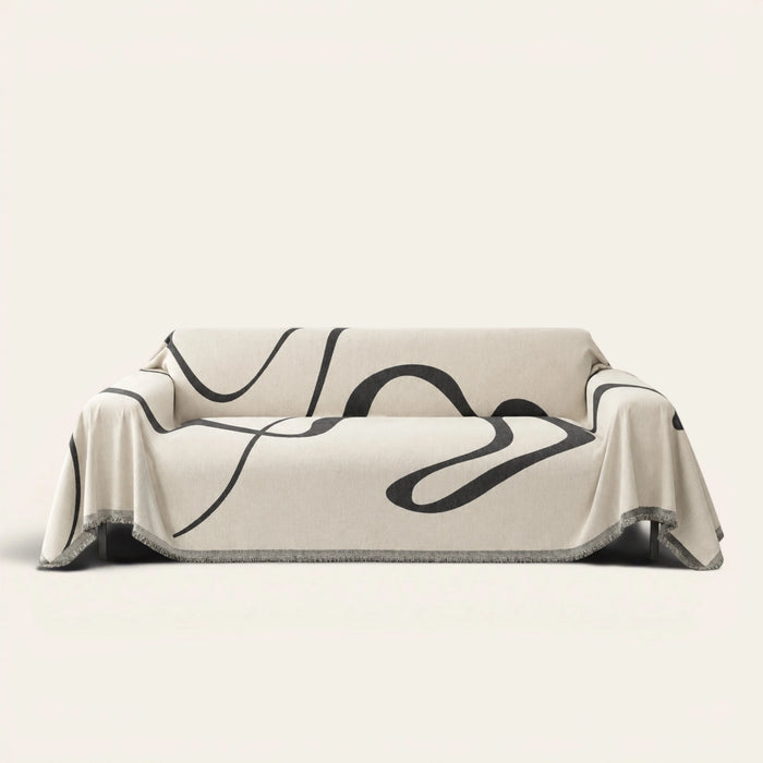 Abstract Haze Abstract Muse sofa throw draped over a full couch, front view on ivory background