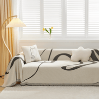Abstract Haze Abstract Muse throw on a sofa with a line-art face cushion beside tulips