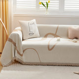 Earth trace Abstract Muse throw styled on a sofa with a line-art cushion and tulips by a window