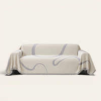 Abstract Muse Monochrome Wave sofa throw draped over a three-seat sofa, front view on ivory