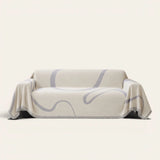 Abstract Muse Monochrome Wave sofa throw draped over a three-seat sofa, front view on ivory
