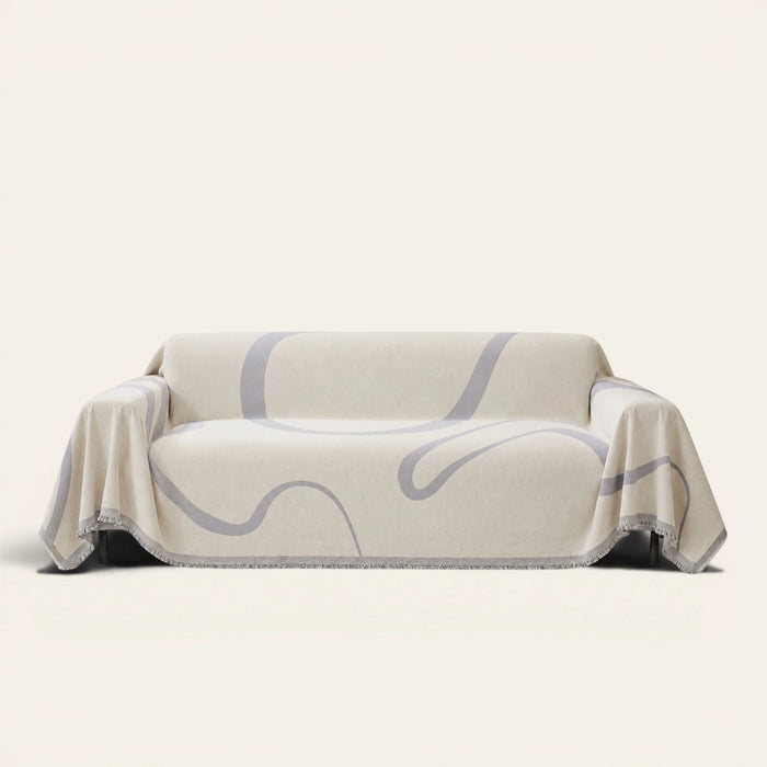 Abstract Muse Monochrome Wave sofa throw draped over a three-seat sofa, front view on ivory