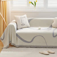 Monochrome Wave Abstract Muse throw styled on a sunlit sofa with a face line-art cushion