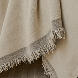 Close-up of the grey bordered fringed edge of the Abstract Muse Monochrome Wave throw