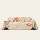 Sunset Stream Abstract Muse sofa throw draped over a full couch, front view on ivory background