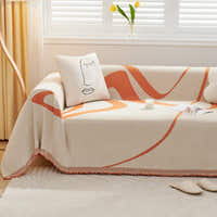 Sunset Stream Abstract Muse throw on a sofa with a line-art face cushion beside tulips