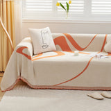 Sunset Stream Abstract Muse throw on a sofa with a line-art face cushion beside tulips