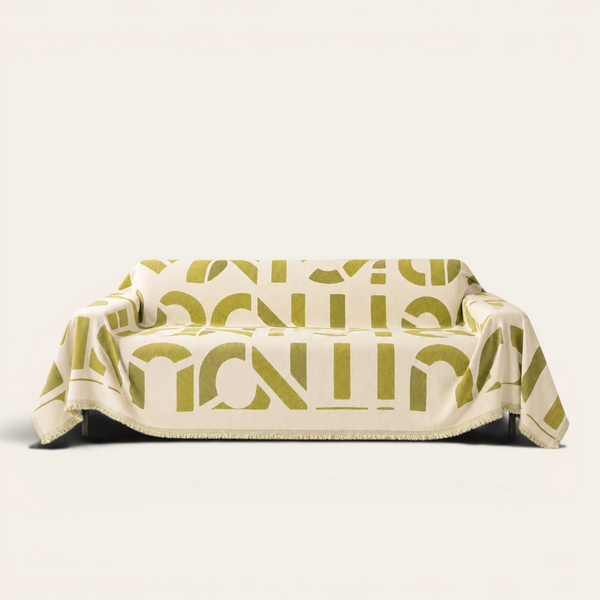 Whispering Fern Abstract Narratives sofa throw draped over a full couch, front view on ivory background