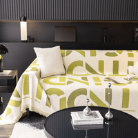 Whispering Fern Abstract Narratives throw on a corner sofa in a moody modern living room