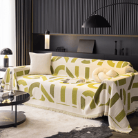 Whispering Fern Abstract Narratives throw over a full sofa with cushions under an arc lamp