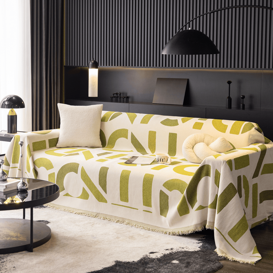 Whispering Fern Abstract Narratives throw over a full sofa with cushions under an arc lamp